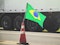 Brazilian flag on a red traffic cone of a highway with a blurred truck on background