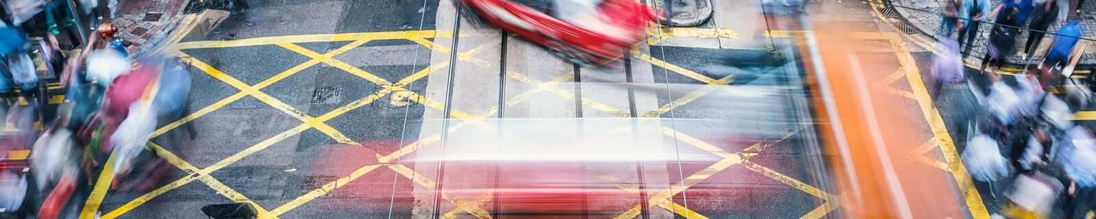 People and taxi cabs crossing a very busy crossroads in the central district, Hong Kong, China