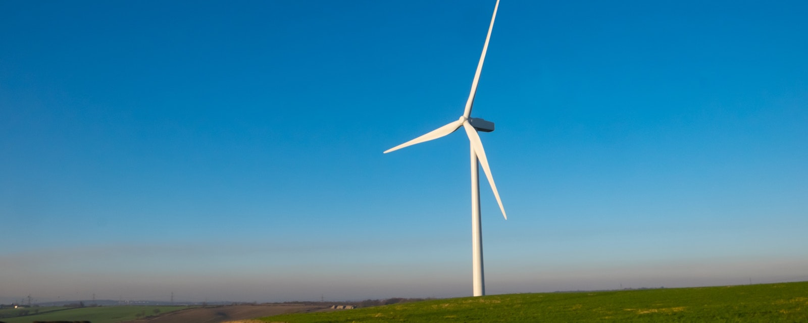 Wind,Turbine,In,English,Countryside,Against,Clear,Blue,Sky.,Wind
